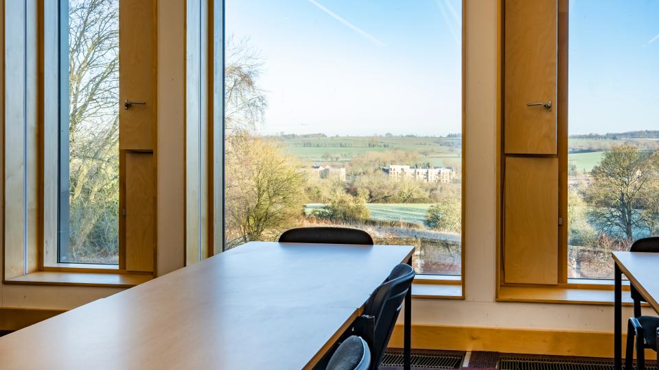 View through a window of Ruskin House, looking out at the countryside and blue sky.