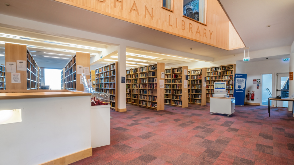 Rows of book shelves showing in Callaghan Library entrance.