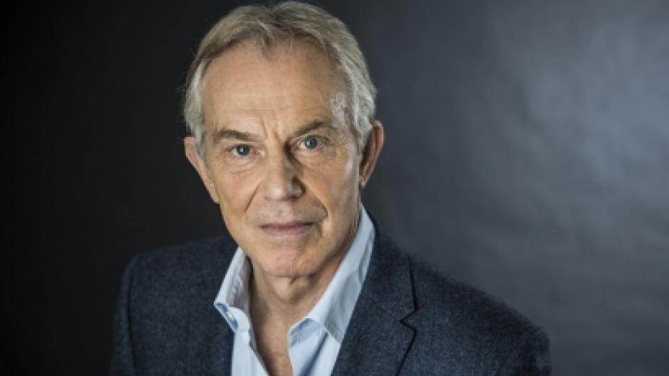 Tony Blair has a dark grey suit and white shirt on.