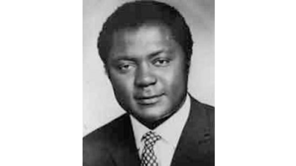 Tom Mboya Has short dark hair and is wearing a suit and tie.