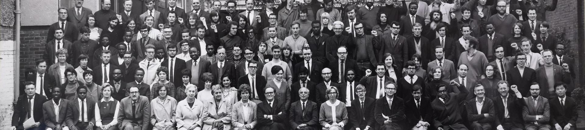 A black and white photo taken in the 1970s of around 100 alumni students.